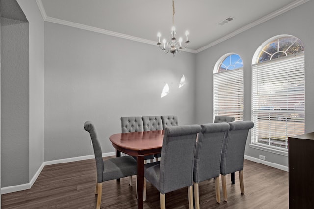 dining space with hardwood / wood-style flooring, crown molding, and a notable chandelier