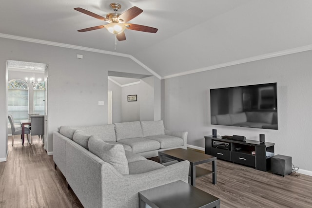 living room with vaulted ceiling, ornamental molding, ceiling fan with notable chandelier, and hardwood / wood-style floors