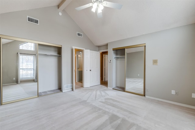 unfurnished bedroom featuring ceiling fan, beam ceiling, high vaulted ceiling, light carpet, and multiple closets