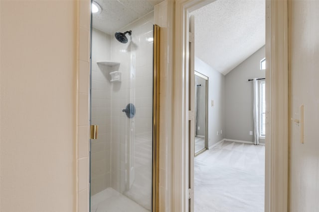 bathroom featuring lofted ceiling, an enclosed shower, and a textured ceiling