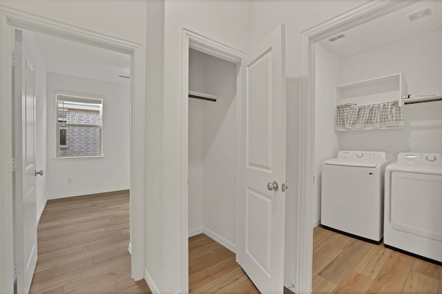 washroom featuring separate washer and dryer and light hardwood / wood-style flooring