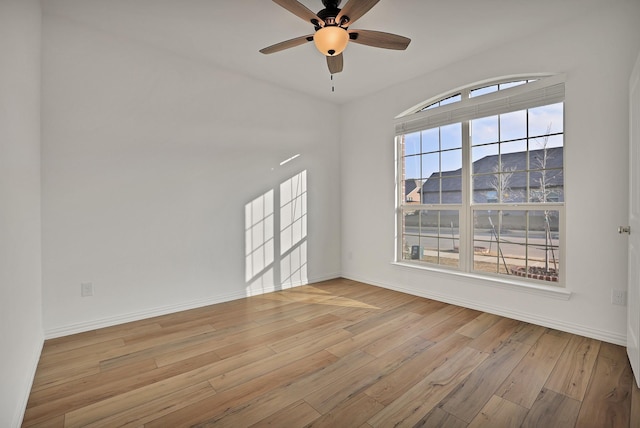 empty room with ceiling fan, a mountain view, light hardwood / wood-style floors, and a wealth of natural light