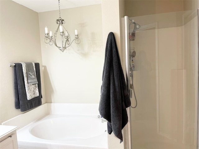 bathroom featuring an inviting chandelier, vanity, and separate shower and tub