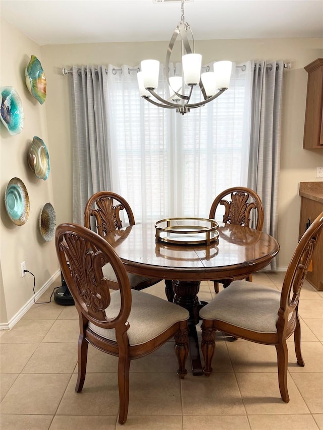 tiled dining room with a notable chandelier