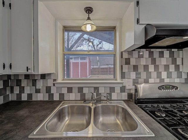 kitchen featuring sink, stainless steel gas stove, range hood, decorative backsplash, and white cabinets