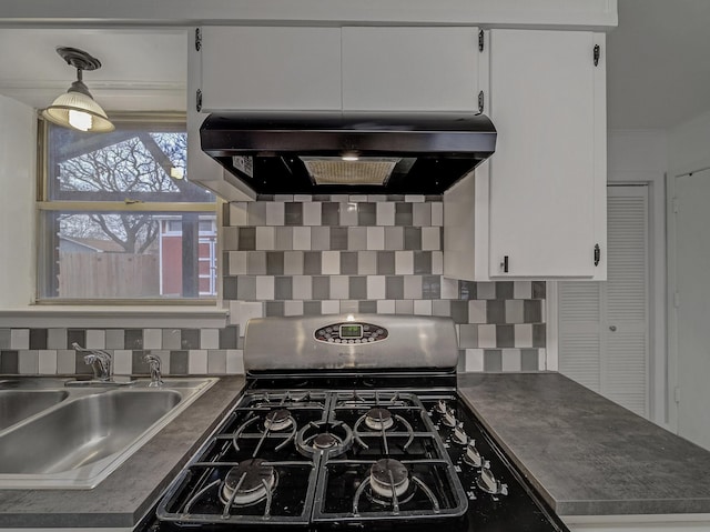 kitchen featuring sink, stainless steel gas range oven, white cabinets, and extractor fan