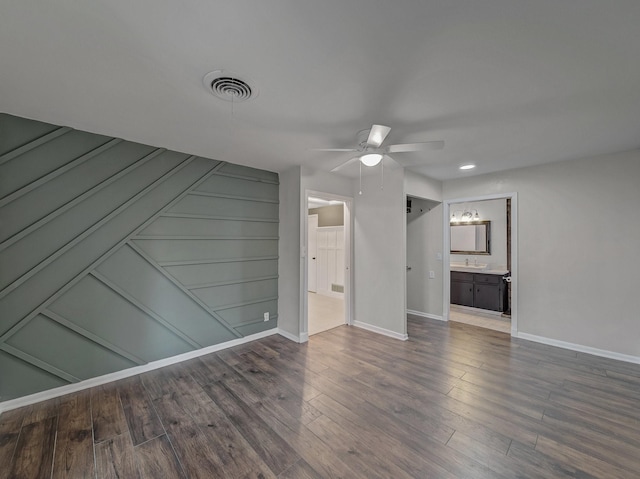 unfurnished living room featuring ceiling fan and dark hardwood / wood-style flooring