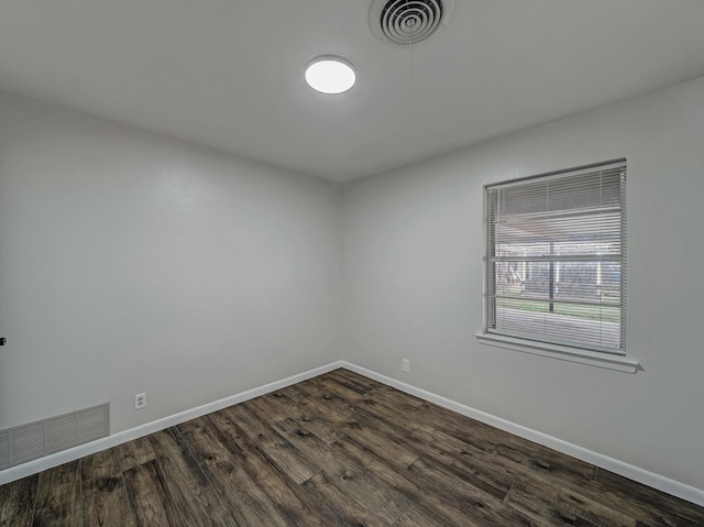 spare room featuring dark wood-type flooring