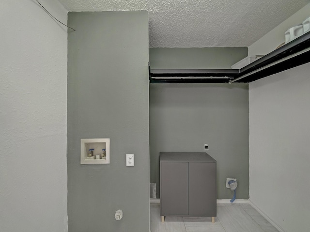 clothes washing area with electric dryer hookup, washer hookup, and a textured ceiling