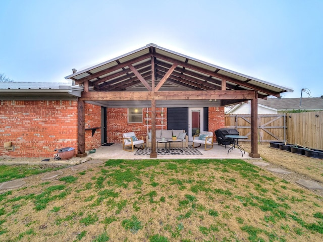 rear view of property with a lawn, outdoor lounge area, and a patio