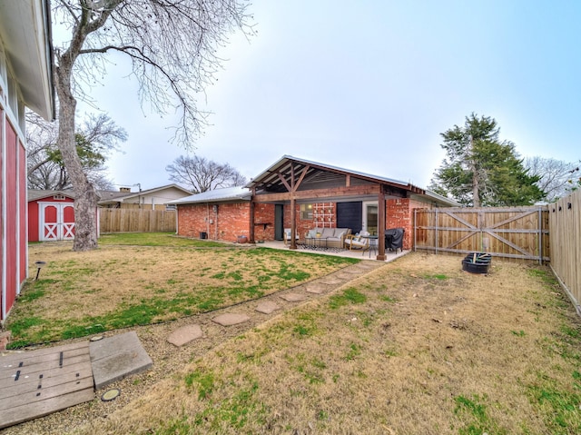 rear view of property with a storage shed, a patio area, and a lawn