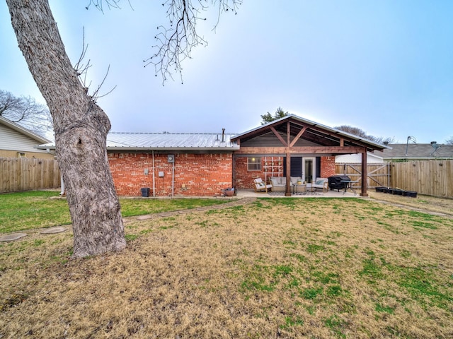 rear view of house with a lawn and a patio