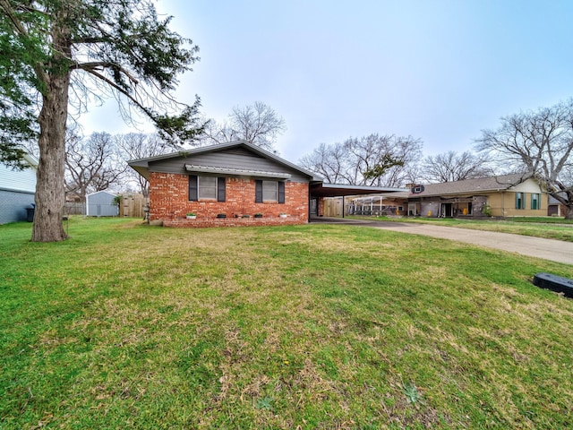 ranch-style home featuring a carport, a storage shed, and a front yard