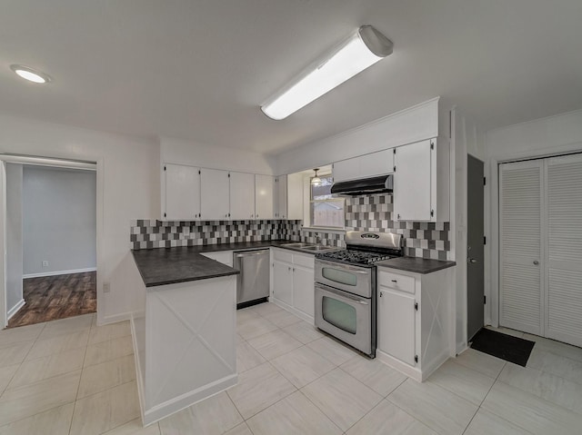 kitchen with light tile patterned floors, sink, appliances with stainless steel finishes, white cabinetry, and backsplash