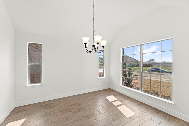 unfurnished dining area with vaulted ceiling, baseboards, wood finished floors, and a chandelier