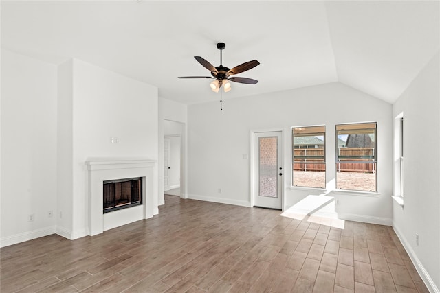 unfurnished living room featuring baseboards, a fireplace, a ceiling fan, and wood finished floors