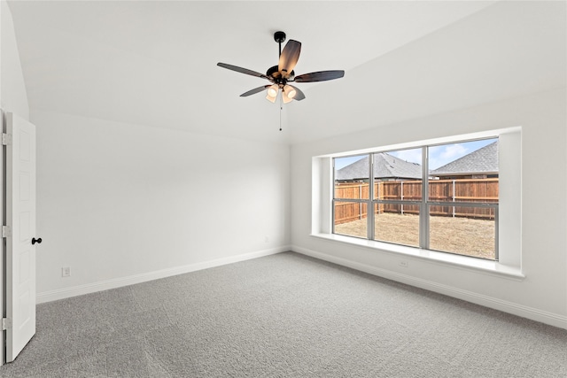 carpeted spare room featuring a ceiling fan and baseboards