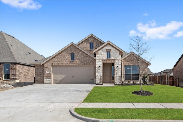 french country home with brick siding, fence, driveway, stone siding, and a front lawn