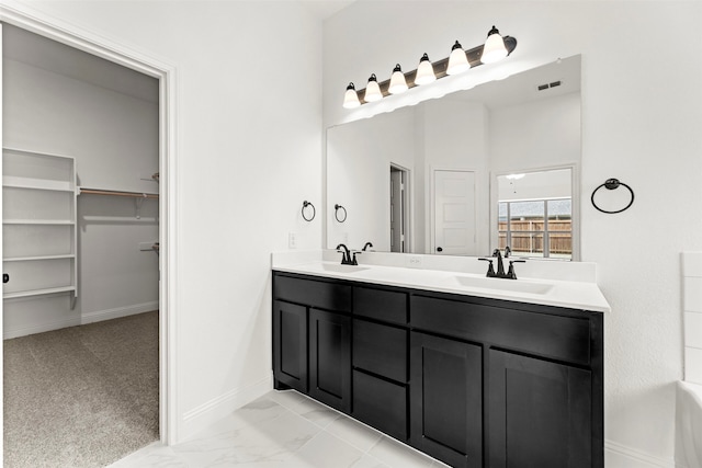 7732 Barley Fld, Joshua, TX 76058 - bathroom with double vanity, baseboards, a walk in closet, and marble finish floors