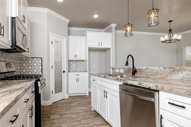 kitchen featuring light stone counters, pendant lighting, stainless steel appliances, and white cabinets