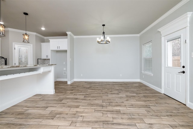 kitchen featuring white cabinetry, light stone countertops, ornamental molding, and light hardwood / wood-style floors