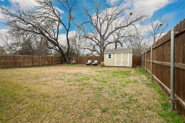 view of yard with a storage unit and a playground