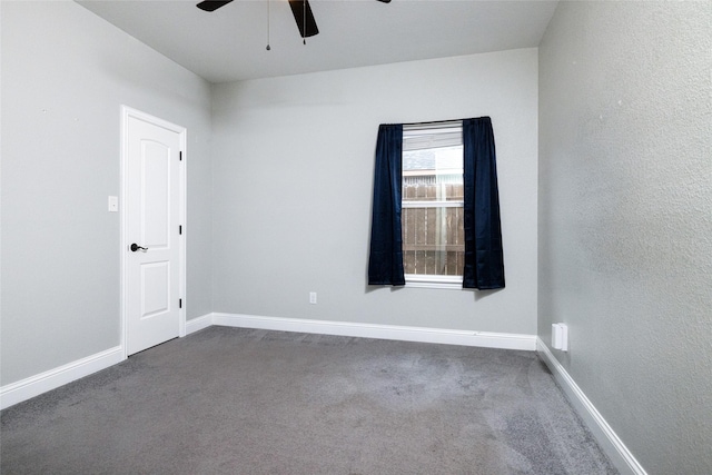 empty room featuring dark carpet and ceiling fan