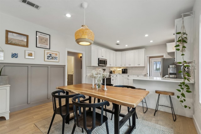 dining space with light hardwood / wood-style floors