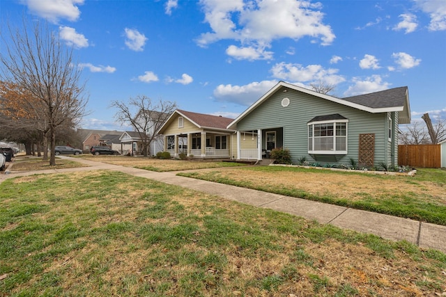 single story home featuring covered porch and a front yard