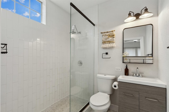 bathroom featuring tiled shower, vanity, and toilet