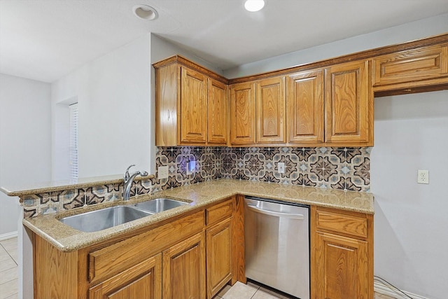 kitchen featuring sink, stainless steel dishwasher, light stone counters, and kitchen peninsula