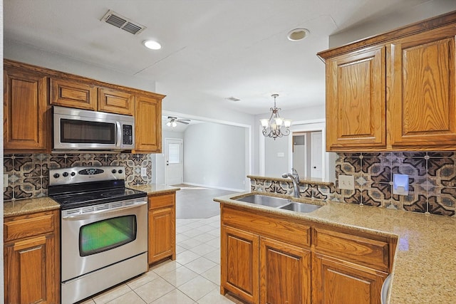 kitchen featuring sink, decorative backsplash, hanging light fixtures, and appliances with stainless steel finishes