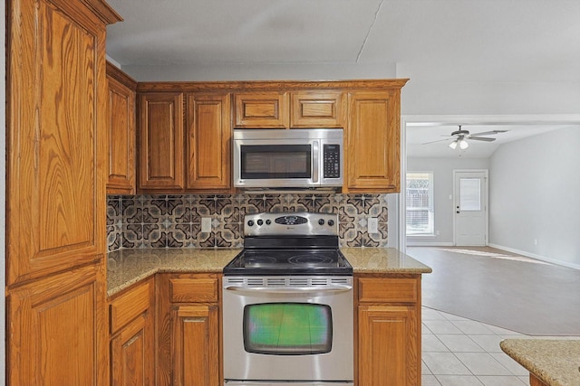 kitchen with tasteful backsplash, light stone counters, and stainless steel appliances