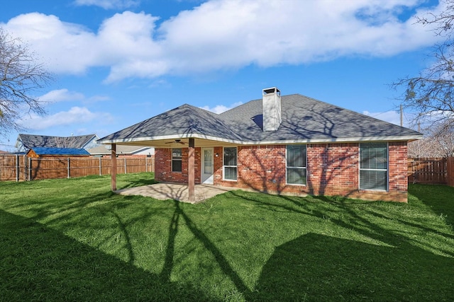 rear view of property featuring a yard and a patio area