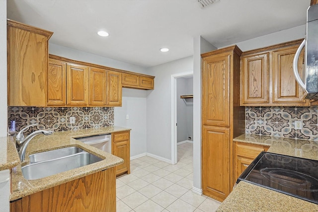 kitchen featuring light tile patterned flooring, sink, decorative backsplash, light stone counters, and stainless steel appliances