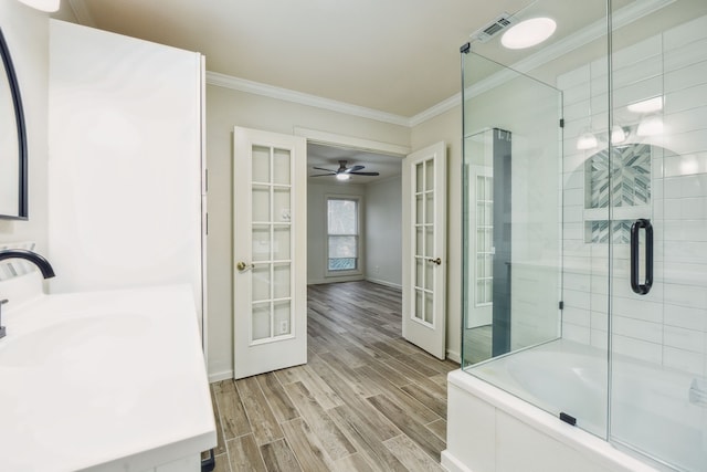 bathroom featuring french doors, ornamental molding, shower with separate bathtub, and vanity