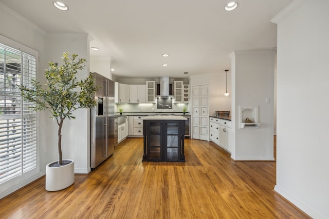 kitchen with pendant lighting, a breakfast bar, white cabinets, a kitchen island, and high end refrigerator