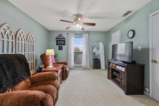 carpeted living room featuring a textured ceiling and ceiling fan