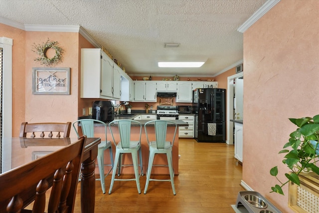 kitchen featuring black appliances, white cabinetry, sink, kitchen peninsula, and crown molding