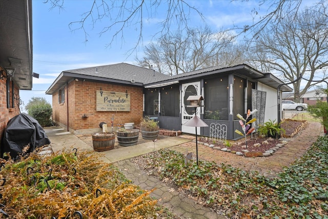 back of property with a patio area and a sunroom