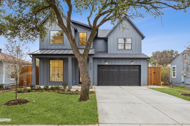 modern inspired farmhouse with a garage and a front lawn