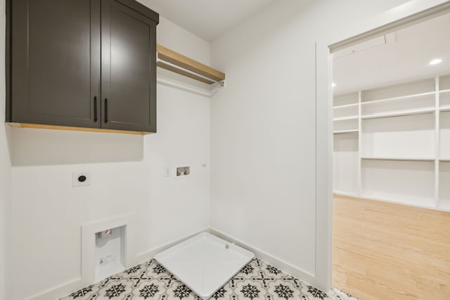 washroom with gas dryer hookup, hardwood / wood-style floors, cabinets, washer hookup, and hookup for an electric dryer