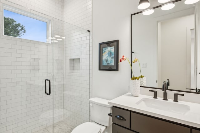 bathroom featuring walk in shower, vanity, and toilet