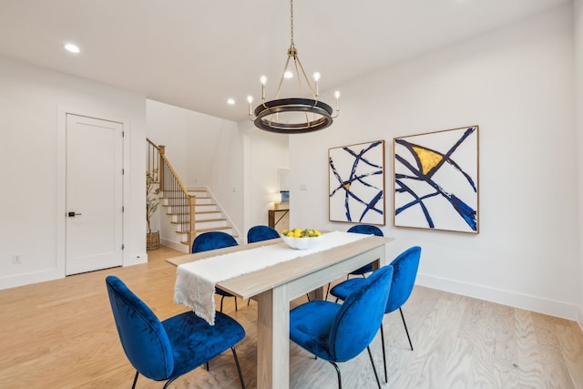 dining space featuring a notable chandelier and light wood-type flooring