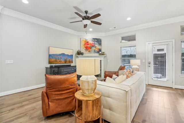 living room featuring crown molding, ceiling fan, and light wood-type flooring