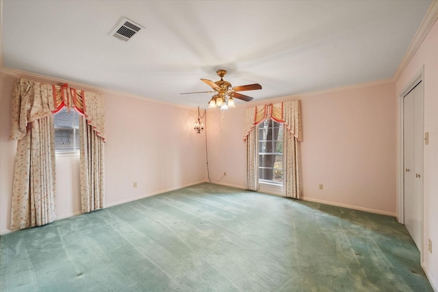 spare room featuring crown molding, carpet flooring, and ceiling fan