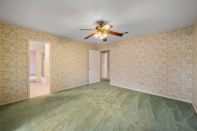 spare room featuring light colored carpet and ceiling fan