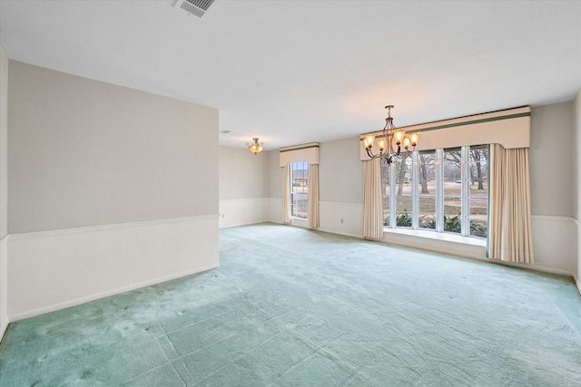 unfurnished room with a chandelier and carpet flooring