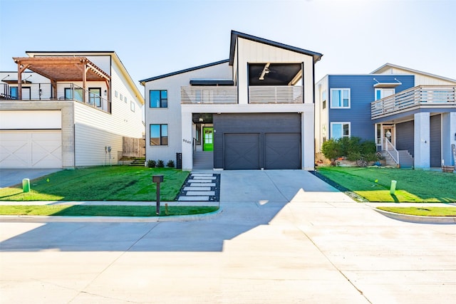 contemporary home featuring a balcony, a garage, and a front yard