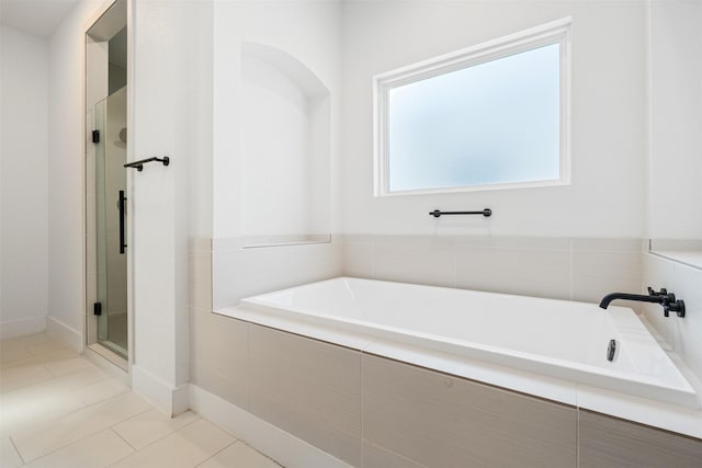 bathroom featuring tile patterned flooring and shower with separate bathtub